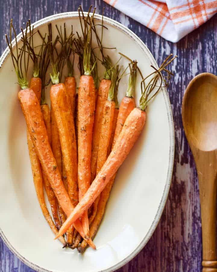 Roasted carrots with dill on a plate.