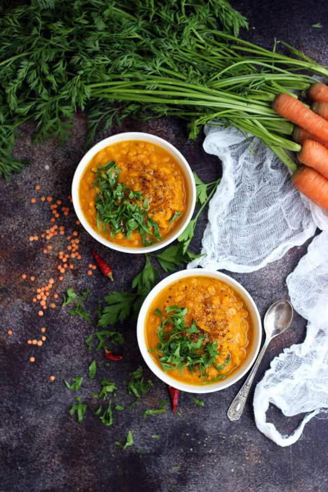Vegan roasted carrot soup with lentils in two bowls.