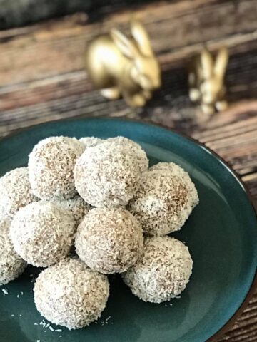 No-bake carrot cake bites on a plate with two bunny figurines.