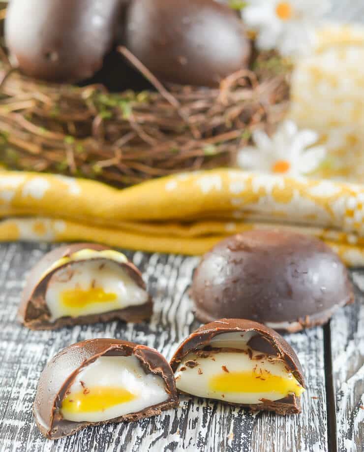Vegan creme eggs opened in front of a basket.