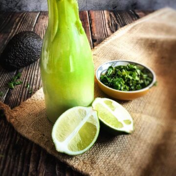 OIl-free cilantro-lime avocado dressing next to limes and cilantro.