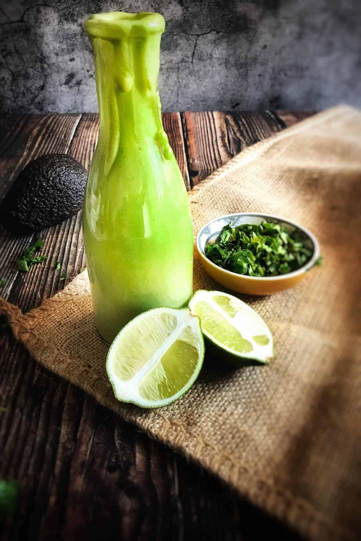 OIl-free cilantro-lime avocado dressing next to limes and cilantro.