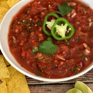 Restaurant-style salsa in a bowl surrounded by tortilla chips.
