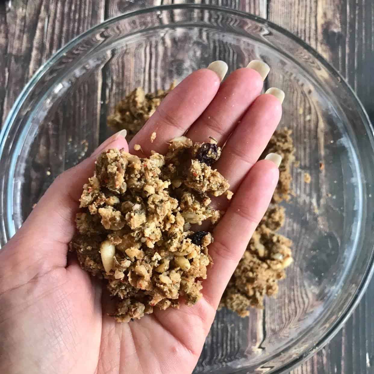 Hand holding roughly 1.5 tablespoons of the lentil mixture.