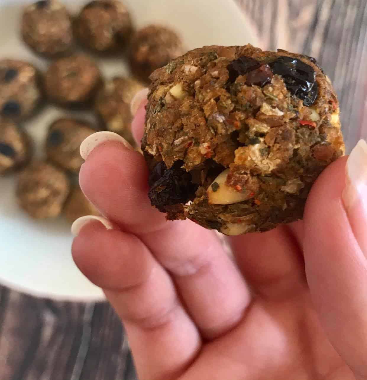 Hand holding a cooked lentil meatball.