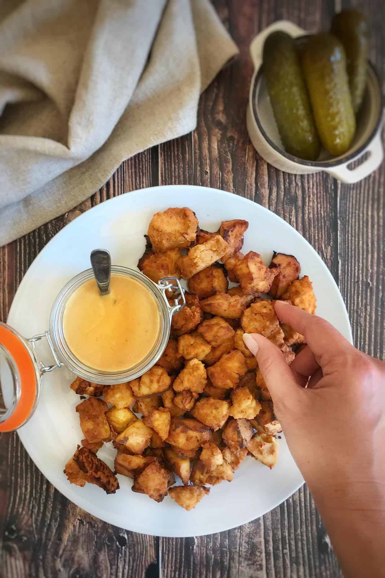 Vegan Chick-fil-A tofu nuggets on a plate with a jar of honey mustard dipping sauce.