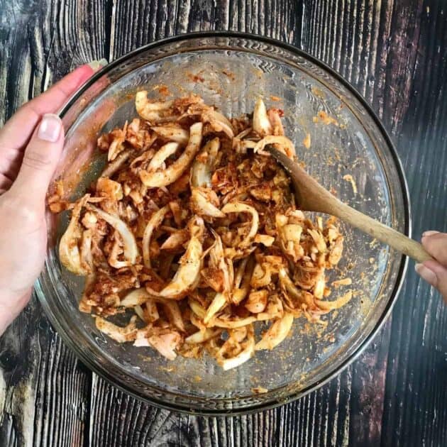 Shredded jackfruit mixed with ingredients in a bowl.