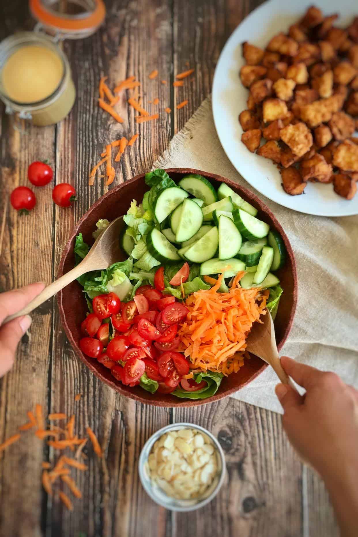 Hands tossing the salad.