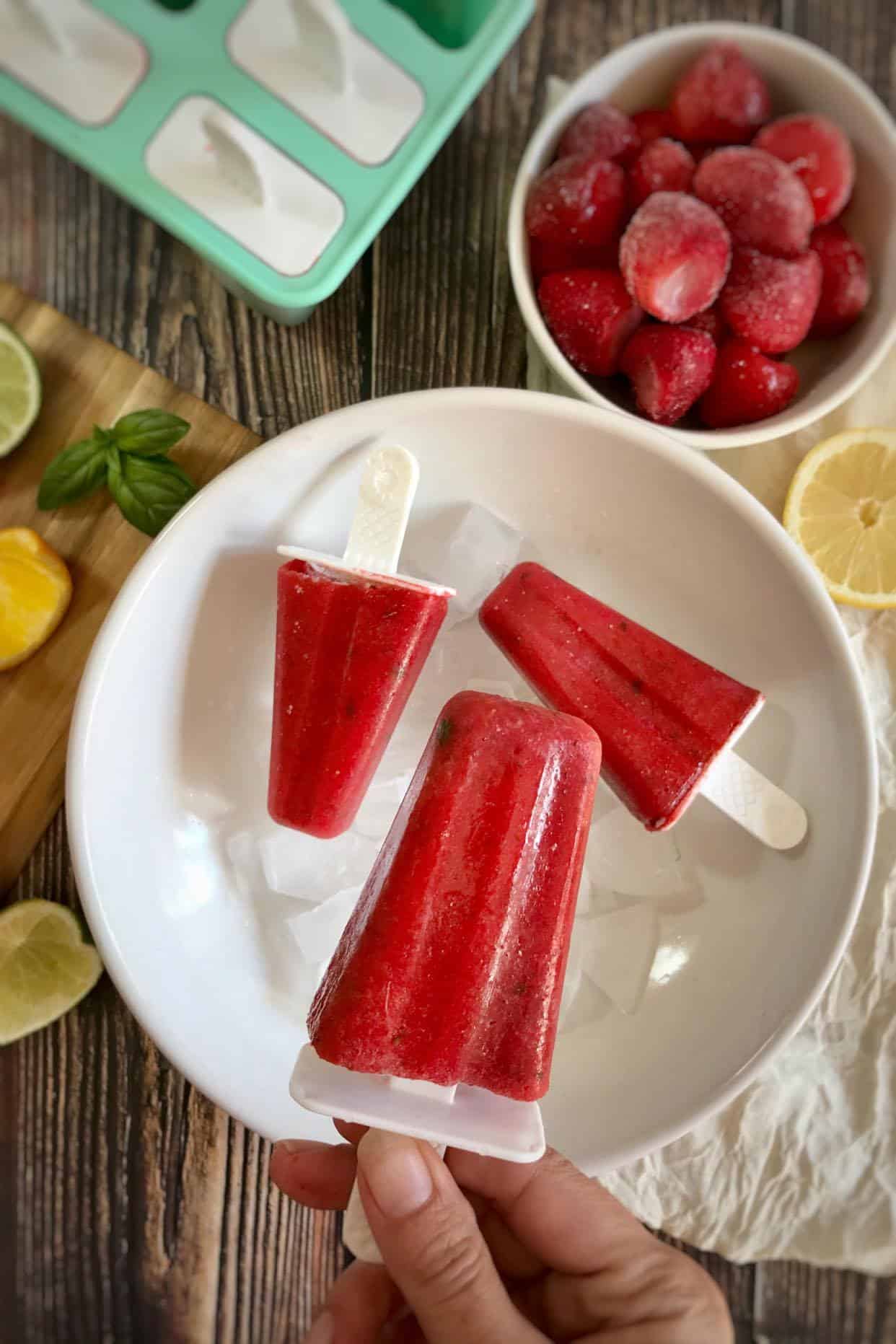 Strawberry popsicles on a plate.