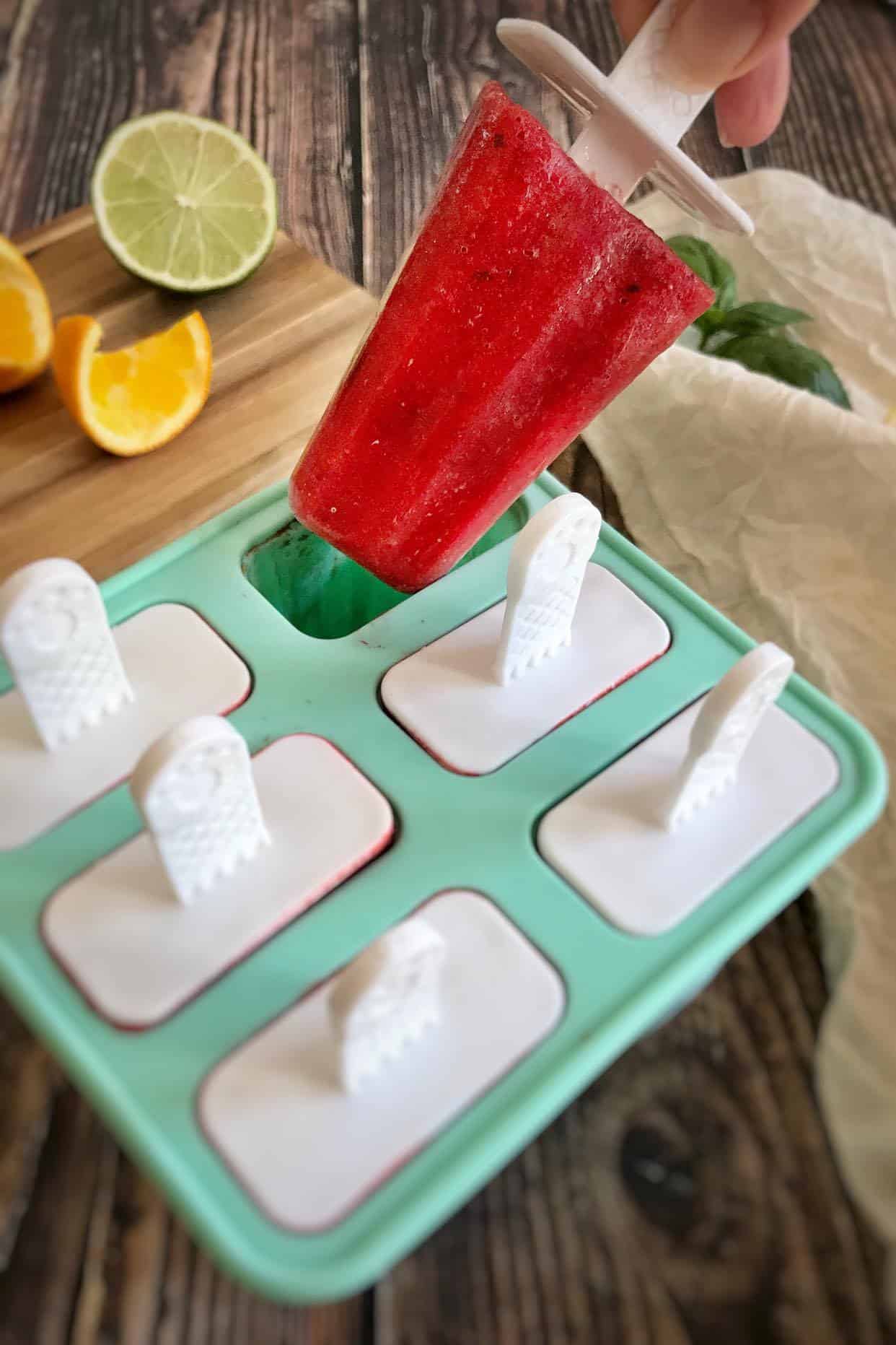 Strawberry popsicle coming out of a form.