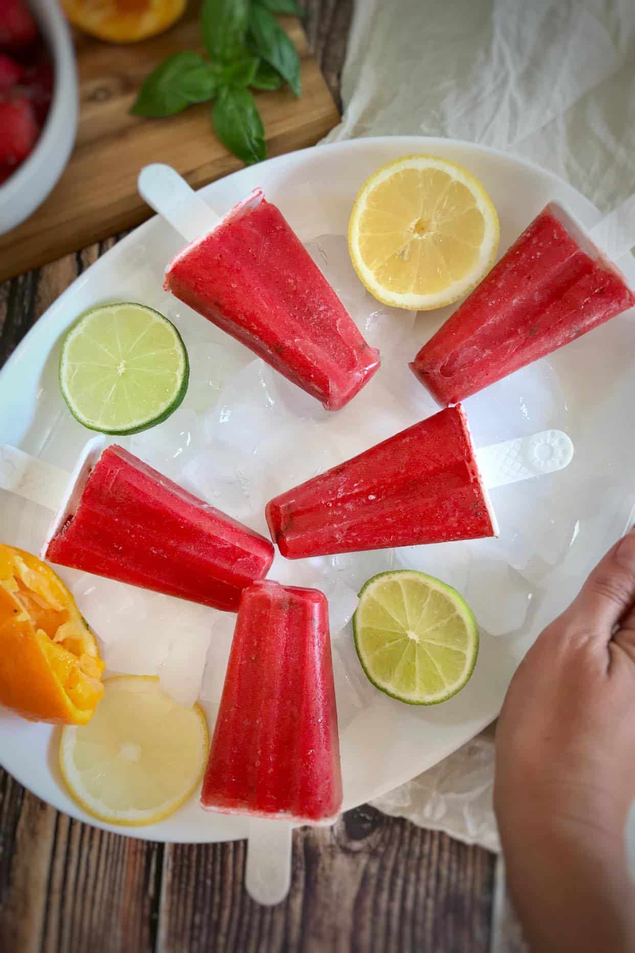 Strawberry popsicles on a plate.