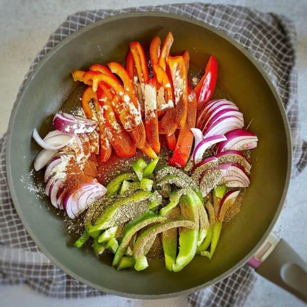Bell peppers and onion in a skillet.