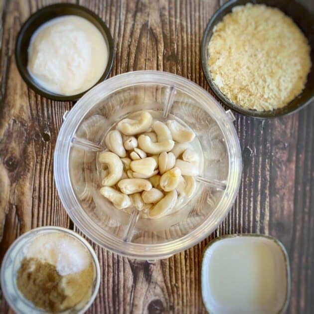 Cashews in a blander surrounded by other ingredients.