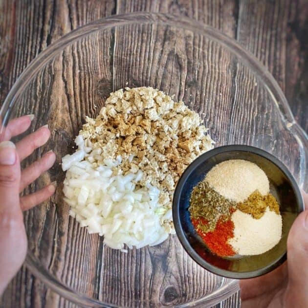 Adding spices and onion to the crumbled tofu.