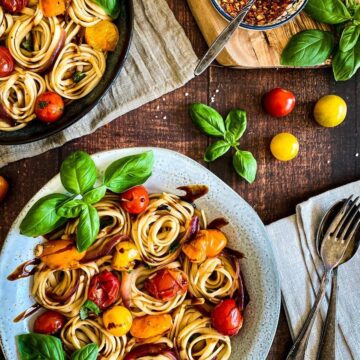 Two bowls of cherry tomato basil pasta.