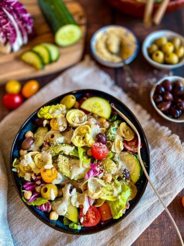 Vegan Italian salad in a bowl with a fork.