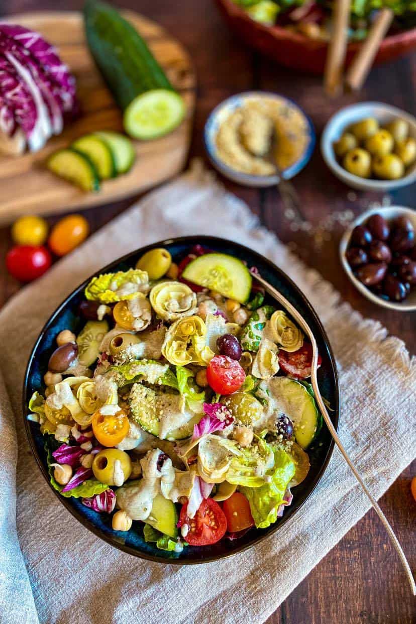Vegan Italian salad in a bowl with a fork.