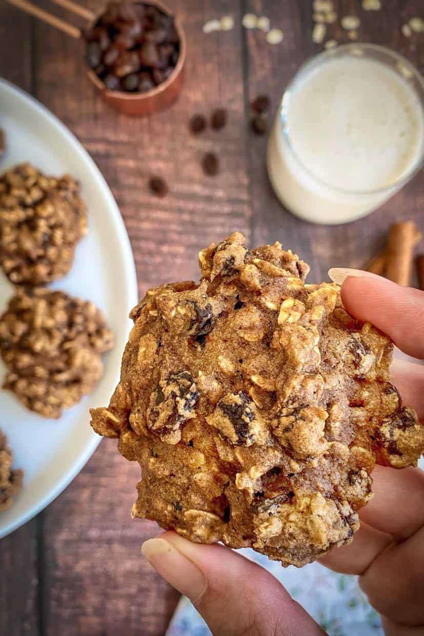 Hand picking up a vegan oatmeal raisin cookie.