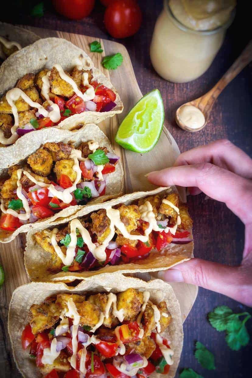 Hand taking a vegan street taco.