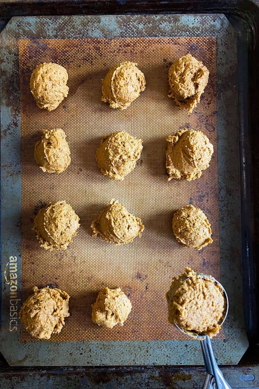 Vegan pumpkin cookies on a lined baking sheet.