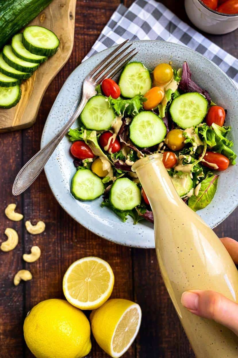 Creamy balsamic dressing being poured over a salad.