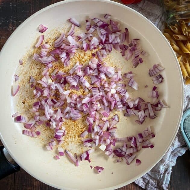 Red onions cooking in a skillet.