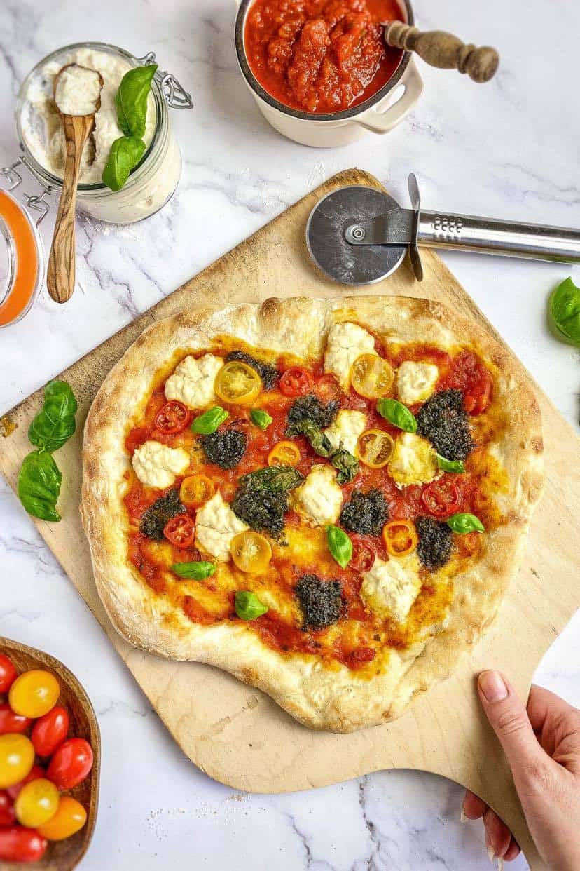 Vegan pesto pizza on a paddle.