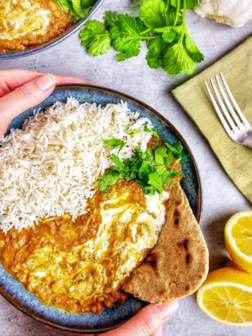 Red lentil dahl in a bowl with rice.