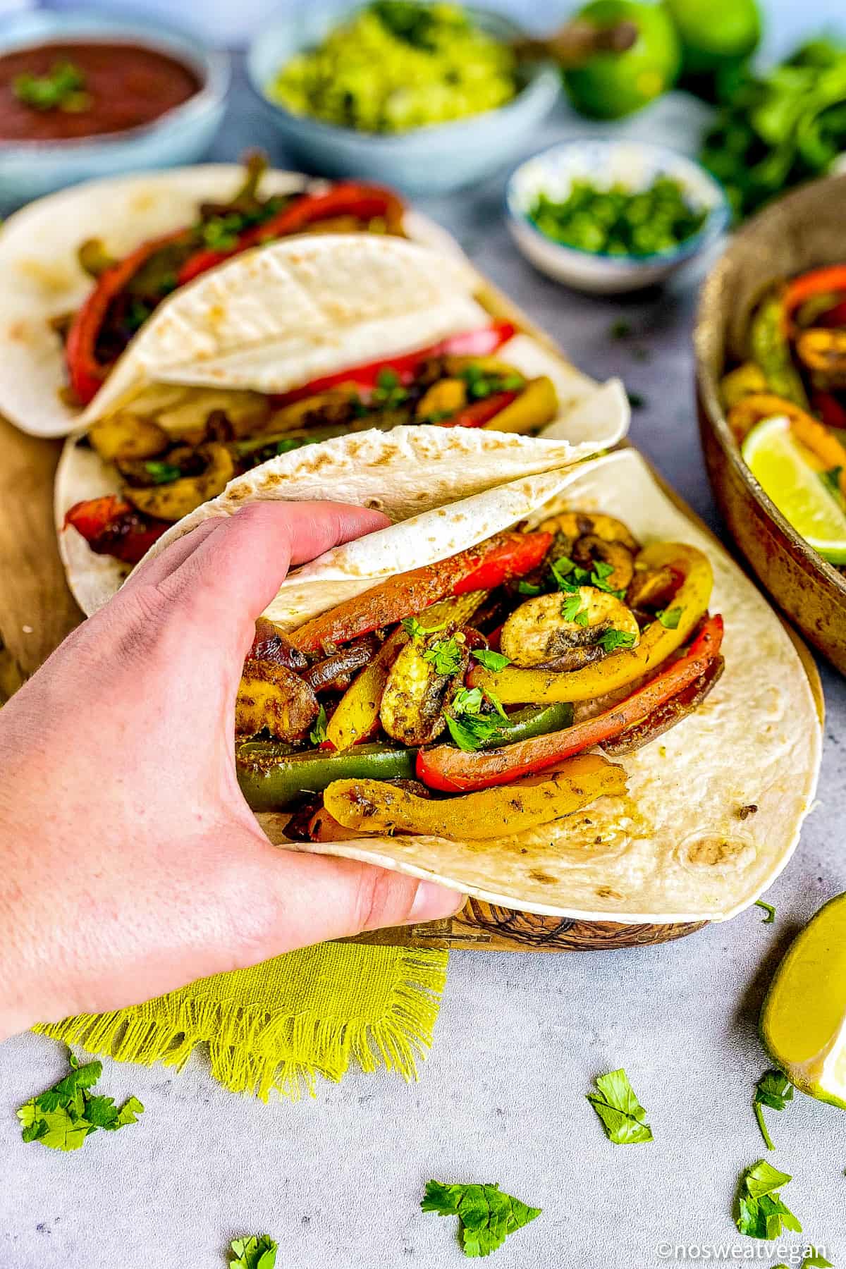 Hand picking up a vegan fajita.