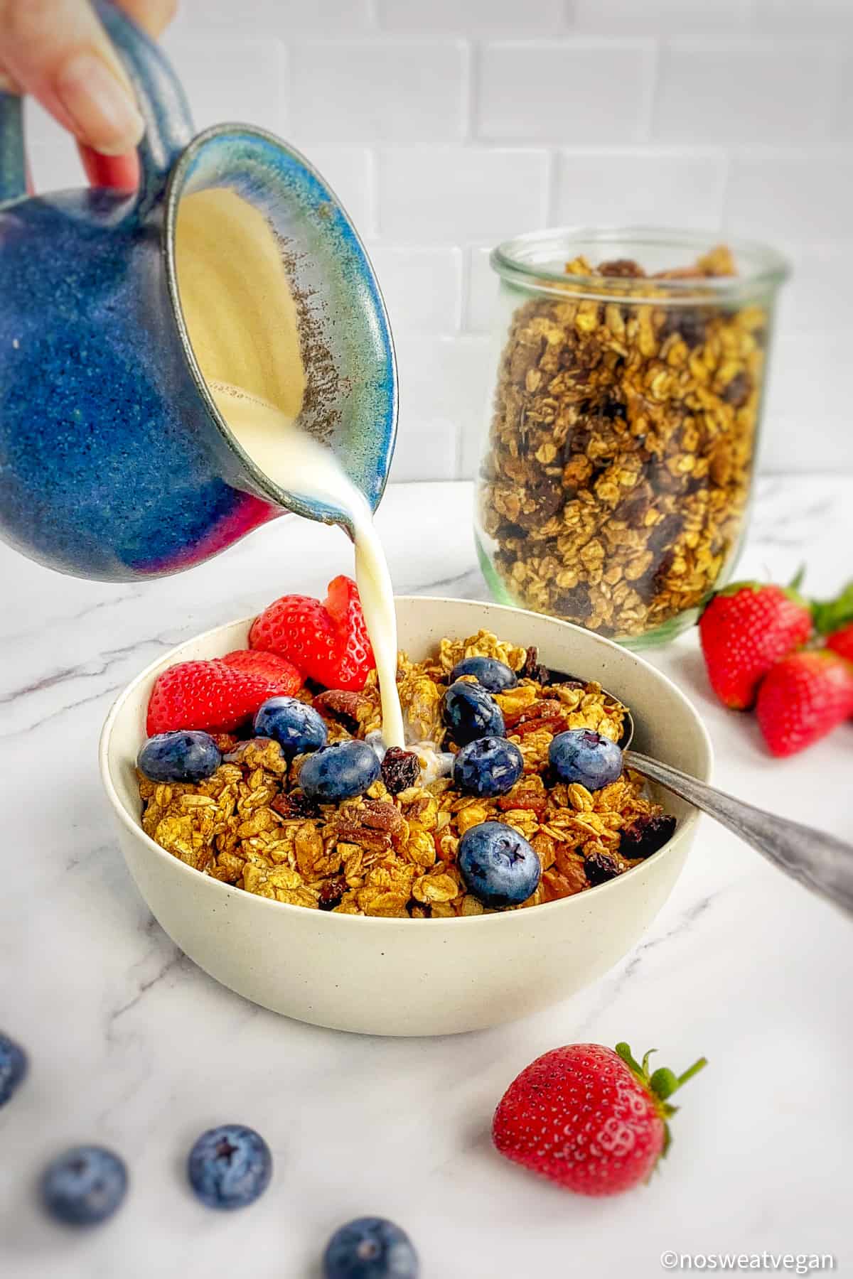 Plant milk being poured into a bowl of vegan granola.