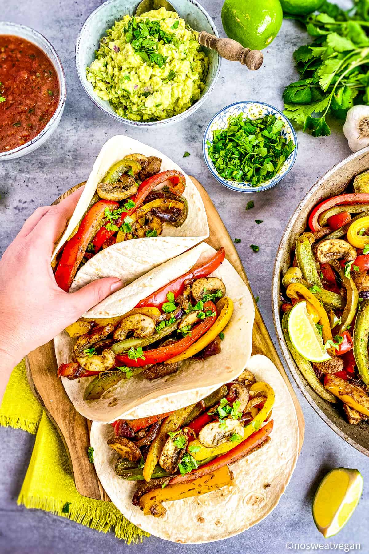 Hand picking up a vegan fajita.
