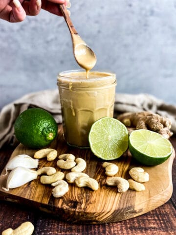 Asian salad dressing in a jar with a spoon lifting up.