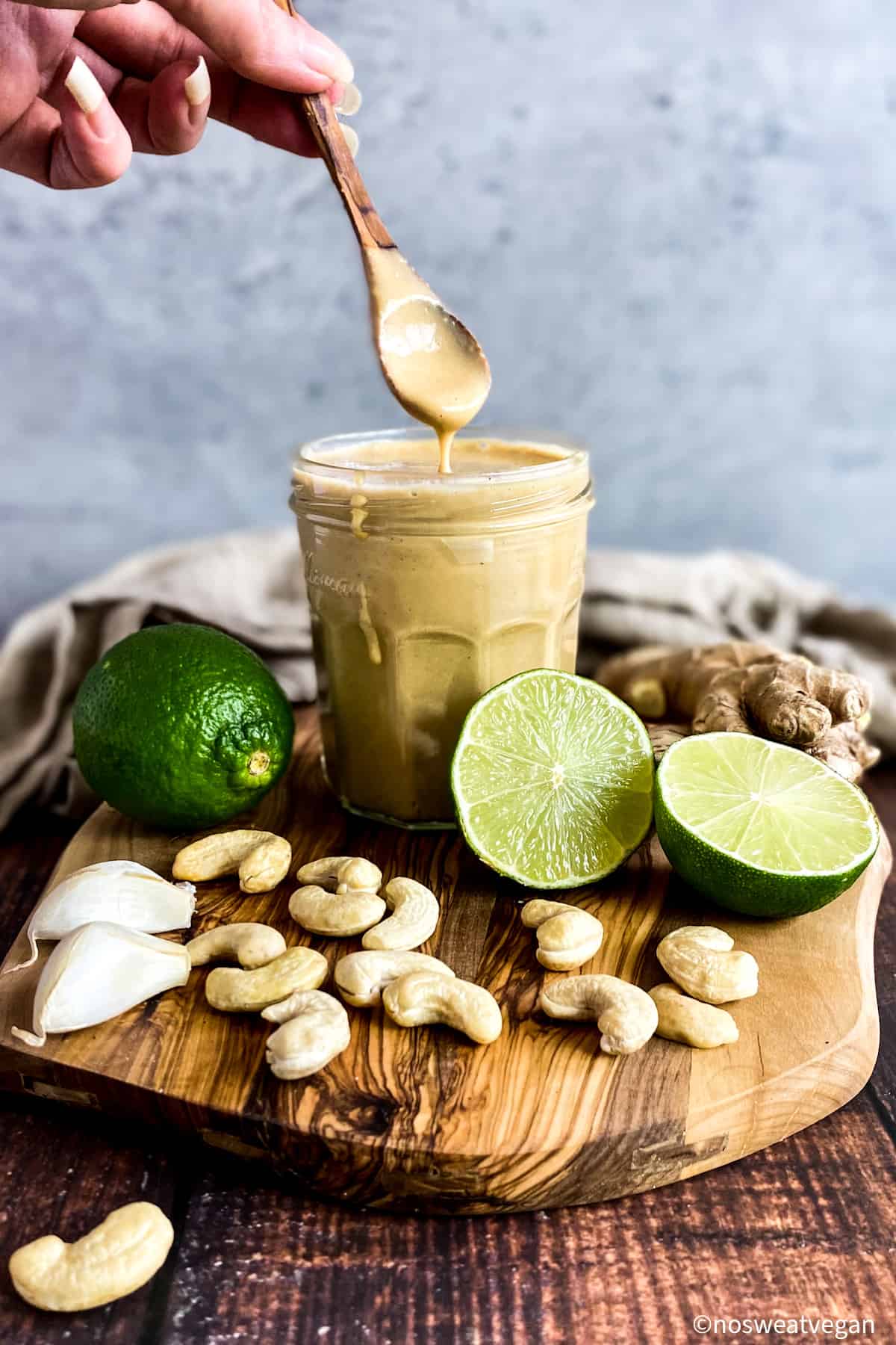 Asian salad dressing in a jar with a spoon lifting up.