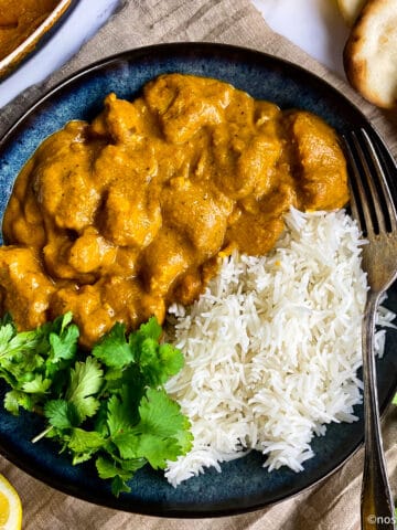Vegan butter chicken in a bowl with rice and cilantro.