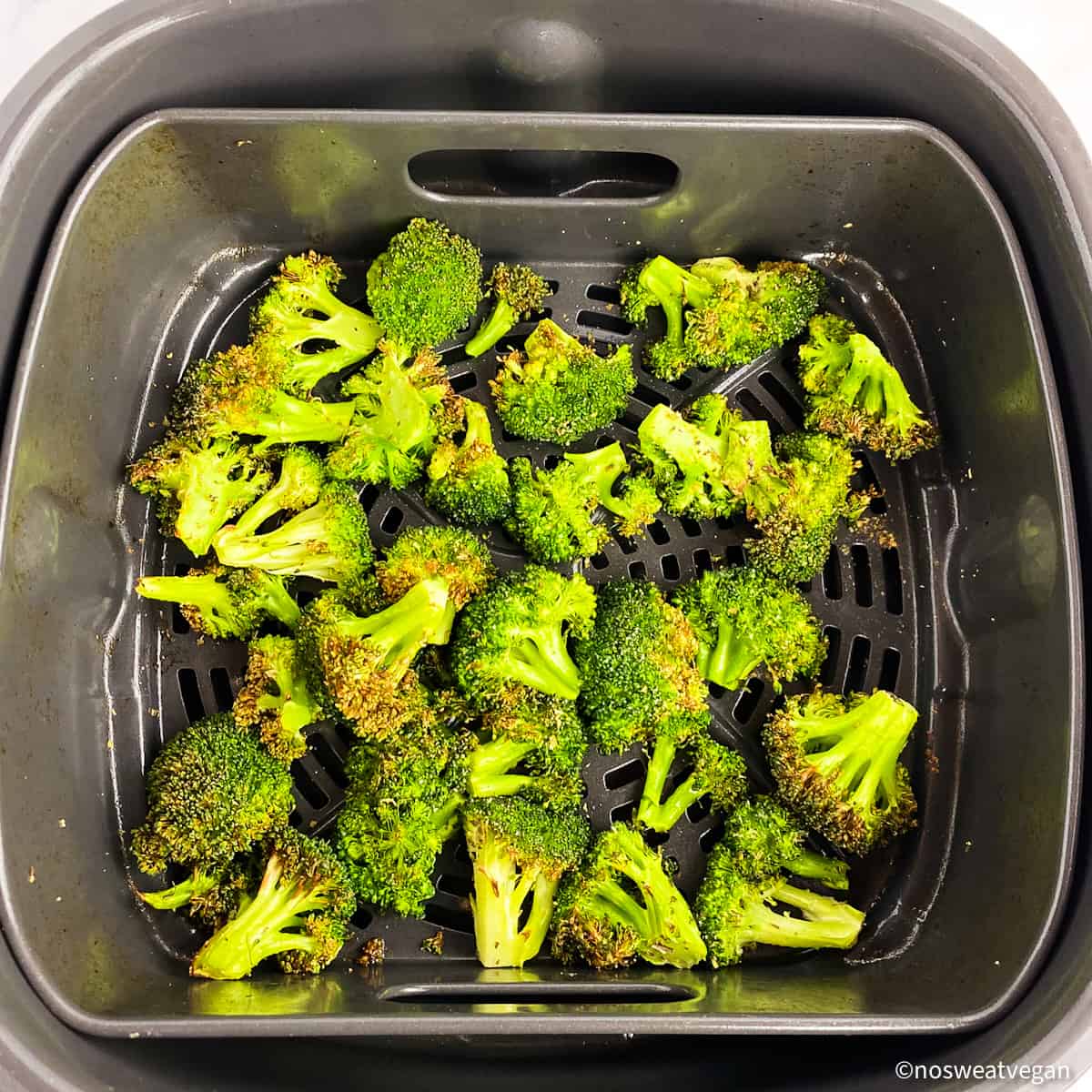 Fresh broccoli roasted in the air fryer basket.