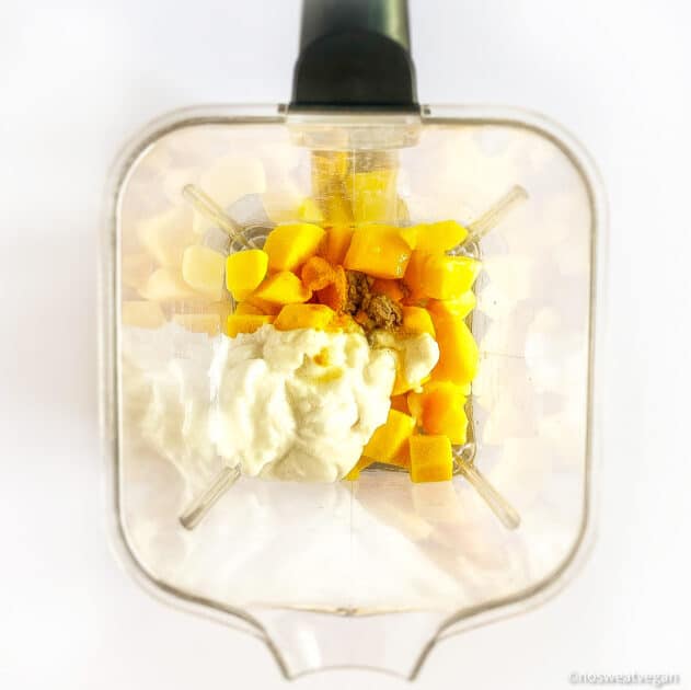 Mango popsicles ingredients in a blender.