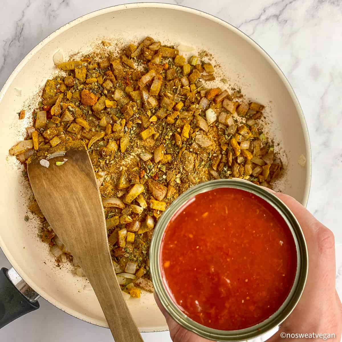 Onions and spices in a skillet. Tomato chunks in a can.