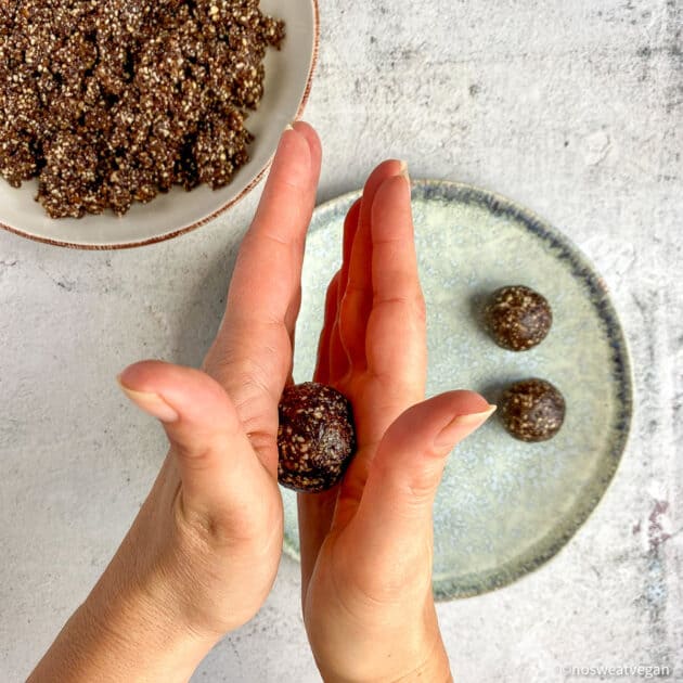 Two hands rolling the dough into small balls.