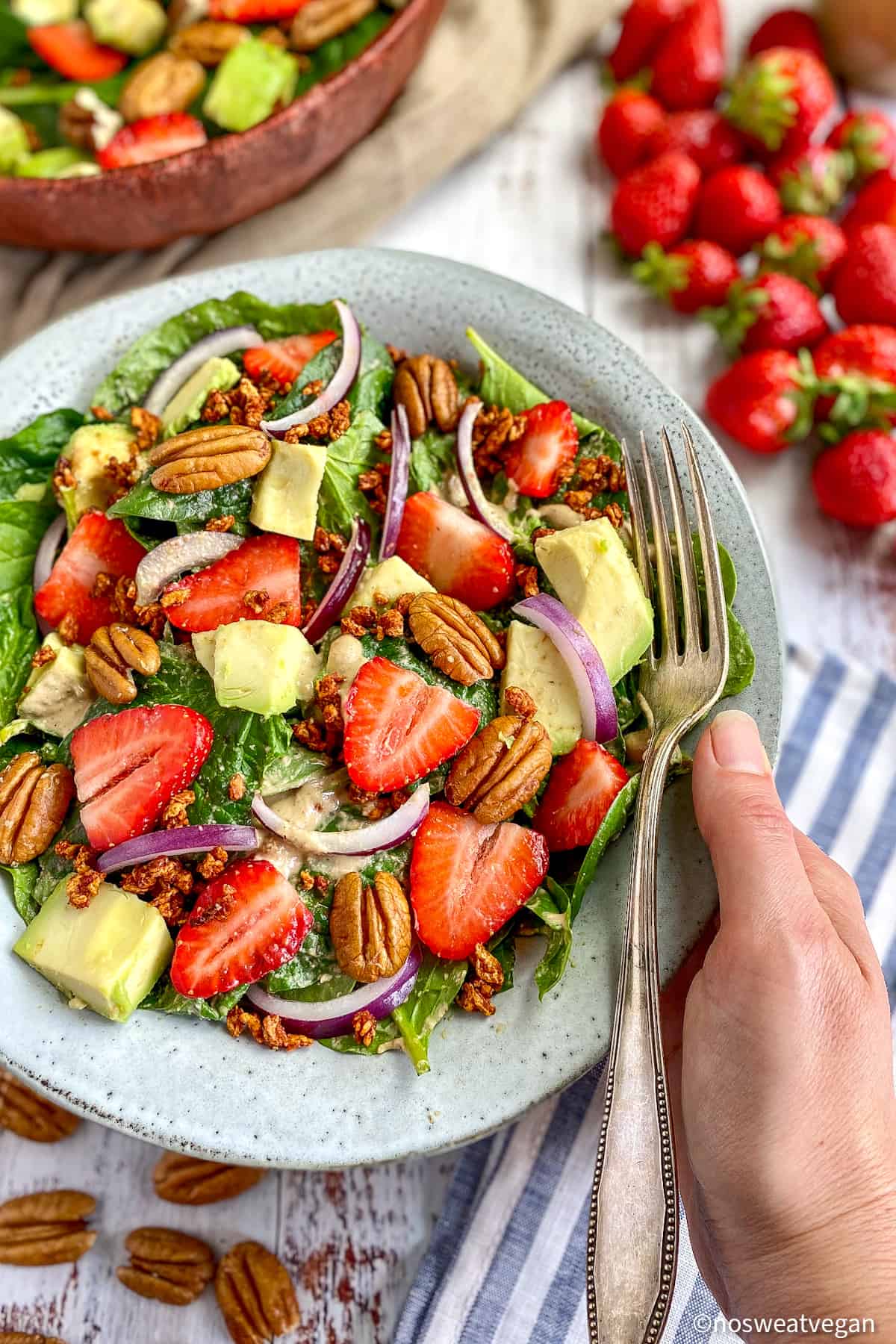 Bowl with vegan spinach strawberry salad.