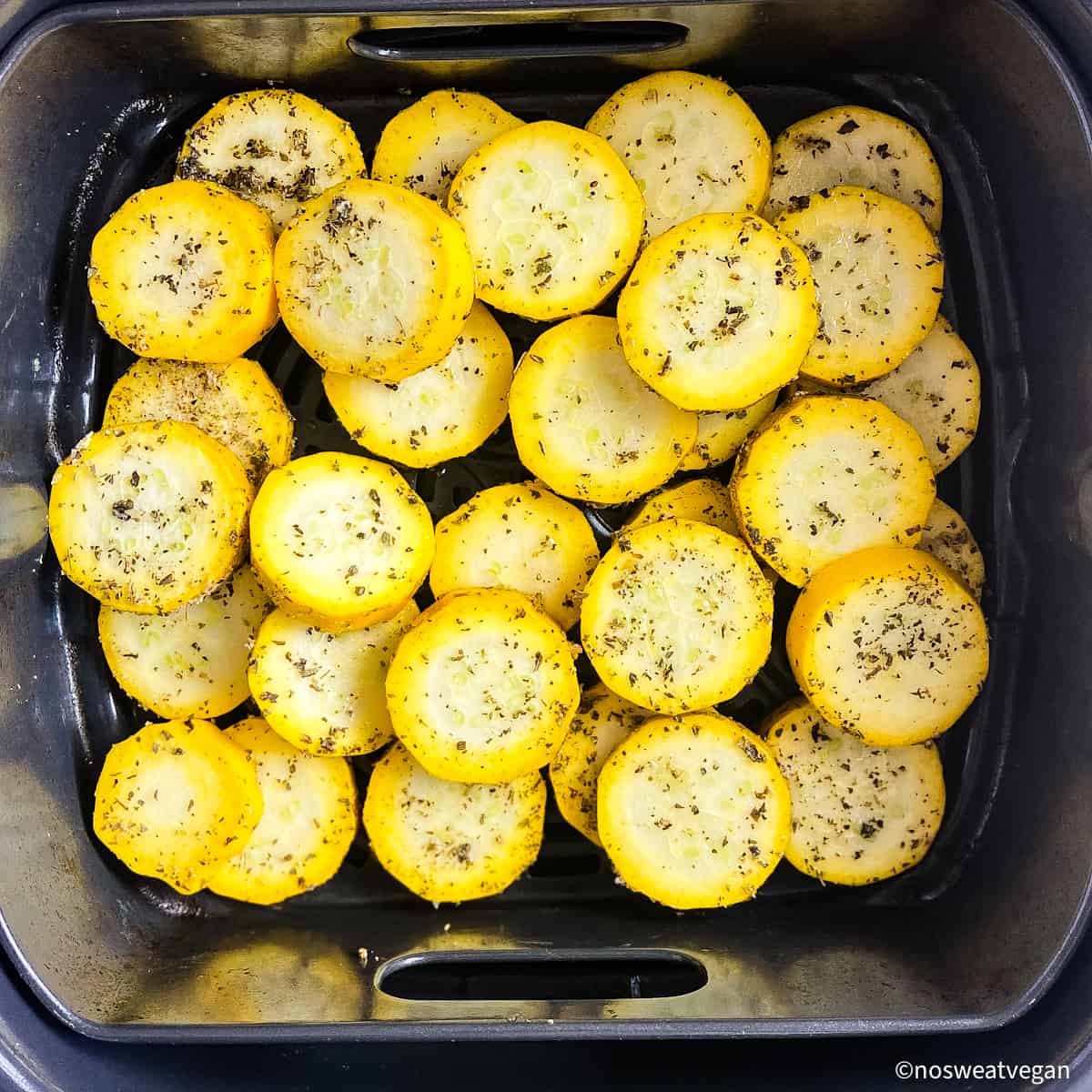 Yellow squash in air fryer basket.
