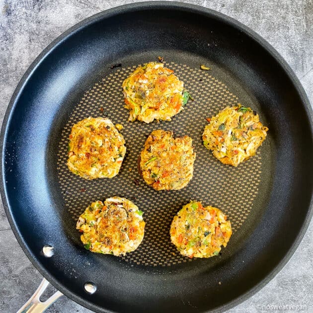 Vegan crab cakes cooked on skillet.