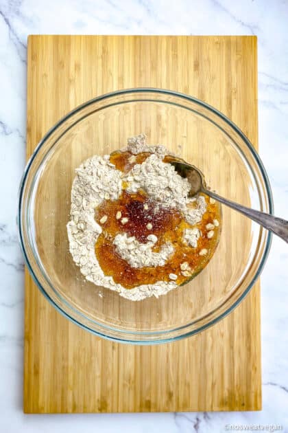 Bowl with flour, oats, maple syrup, and other crumble ingredients.