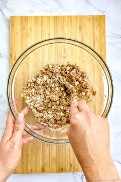 Hand mixing the oat crumble topping.