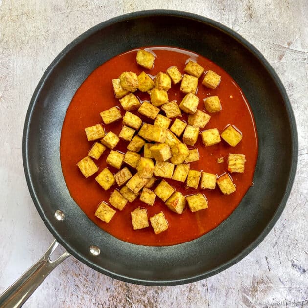Tofu cubes in skillet with sauce (not mixed).