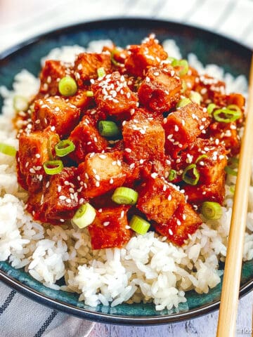 Vegan Korean tofu in bowl with rice and chopsticks.