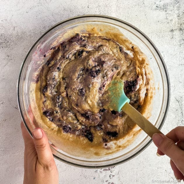 Mixing blackberries into the dariy-free muffin batter.