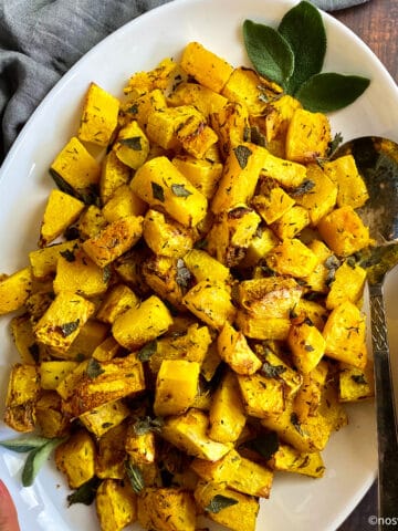 Air fryer butternut squash on plate with sage.
