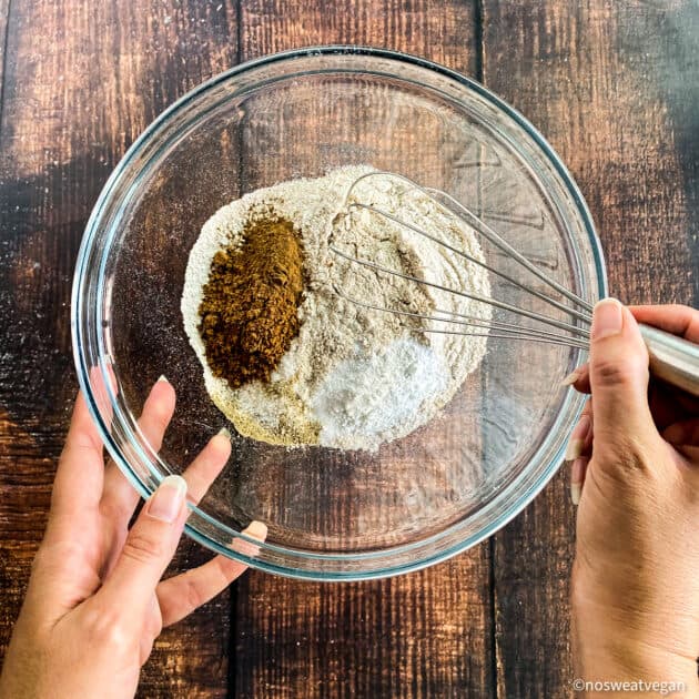 Hand mixing dry ingredients for vegan pumpkin muffins.