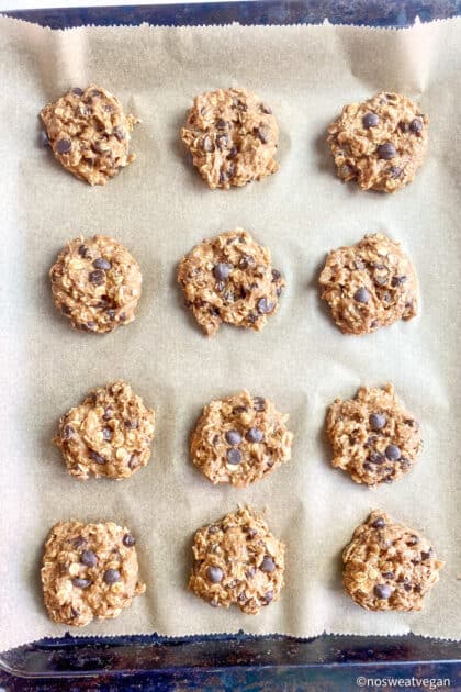 Uncooked vegan oatmeal cookies on baking sheet.
