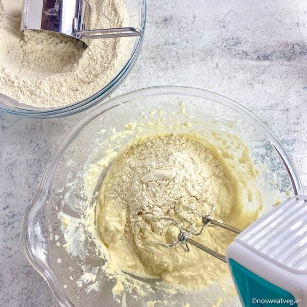 Bowl with flour being added to creamed ingredients.